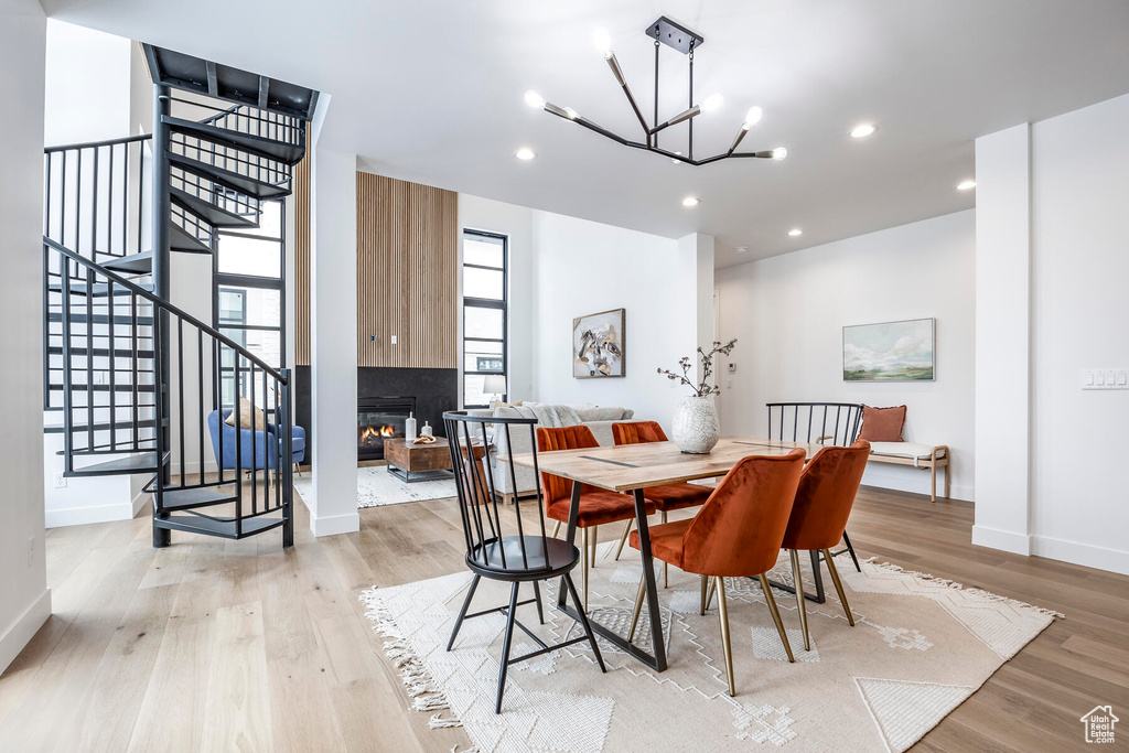 Dining room with light hardwood / wood-style flooring and a chandelier