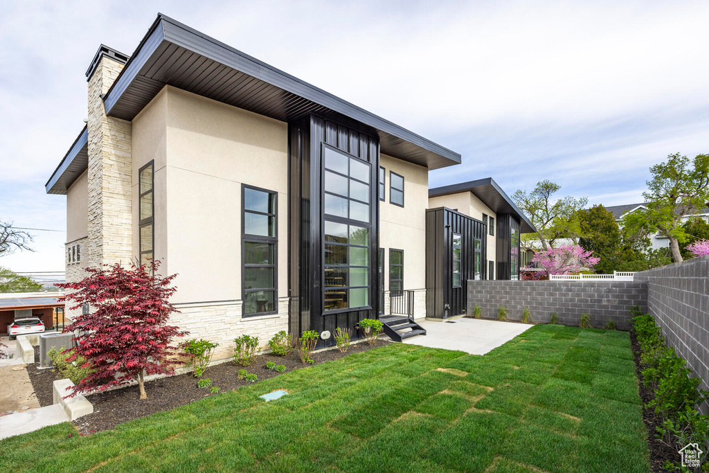 Rear view of property with a lawn