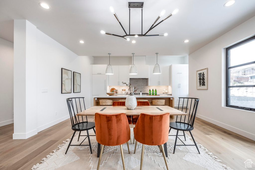 Dining space featuring a notable chandelier and light hardwood / wood-style floors