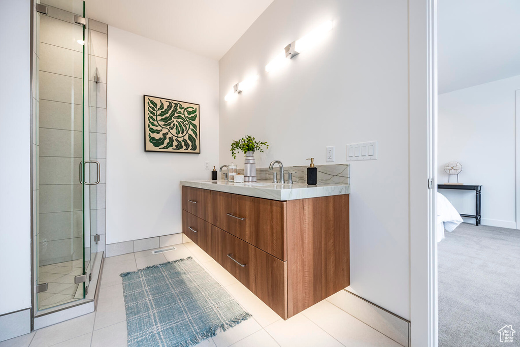 Bathroom featuring vanity, walk in shower, and tile patterned flooring