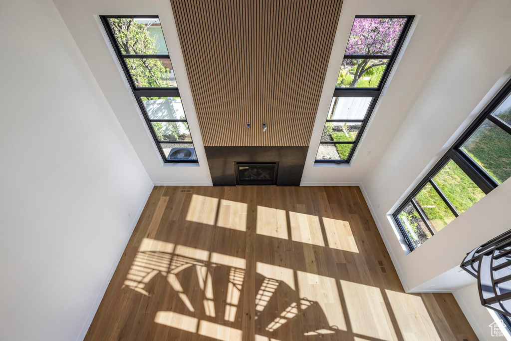 Living room with plenty of natural light, a high ceiling, and hardwood / wood-style flooring