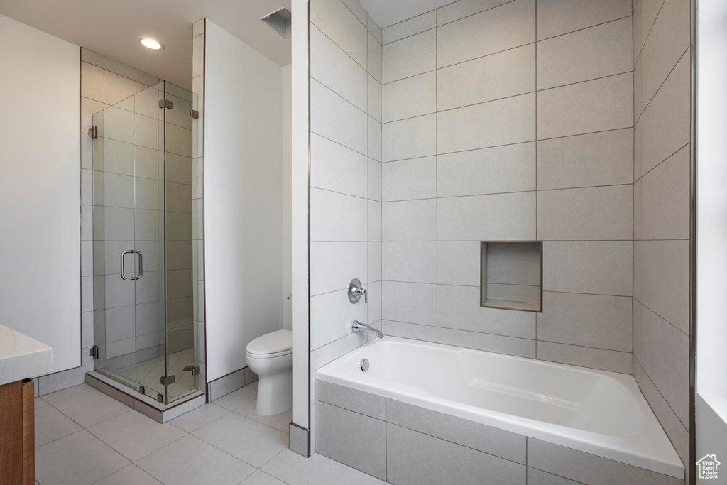 Full bathroom featuring vanity, toilet, tile patterned floors, and shower with separate bathtub