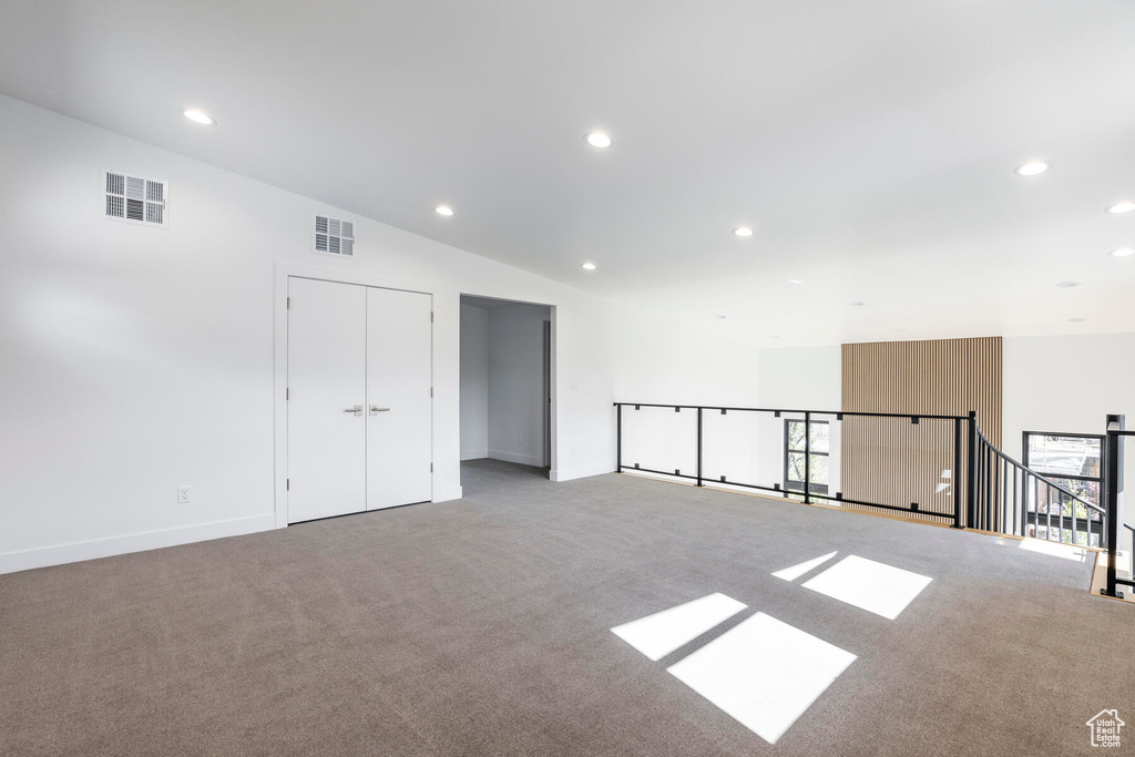 Empty room featuring vaulted ceiling and light colored carpet