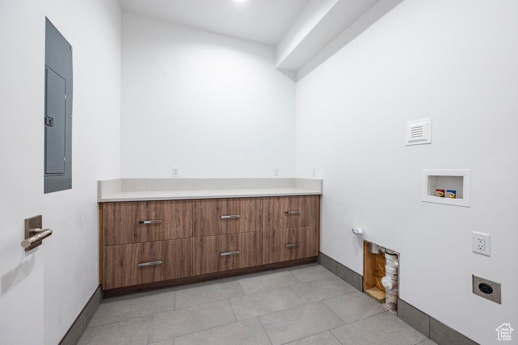 Laundry room featuring light tile patterned floors, gas dryer hookup, electric panel, electric dryer hookup, and washer hookup