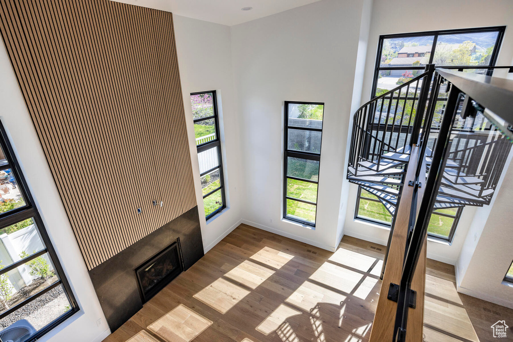 Entrance foyer featuring a towering ceiling and light hardwood / wood-style floors