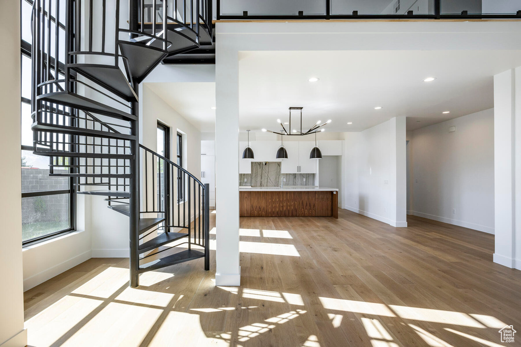 Living room with light hardwood / wood-style floors and a chandelier