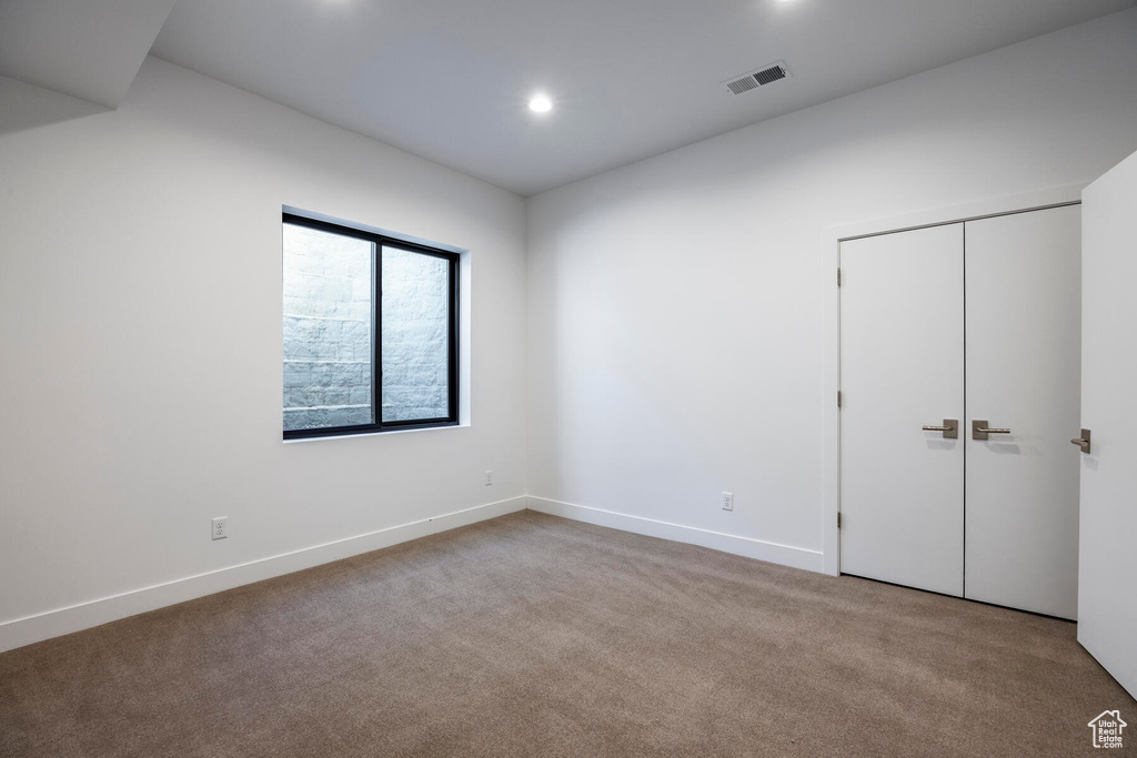 Unfurnished bedroom with light carpet and a closet