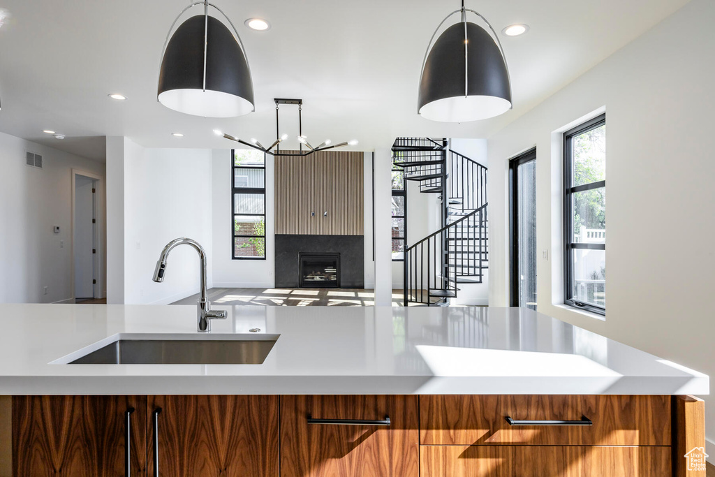 Kitchen featuring a healthy amount of sunlight, sink, a notable chandelier, and hanging light fixtures