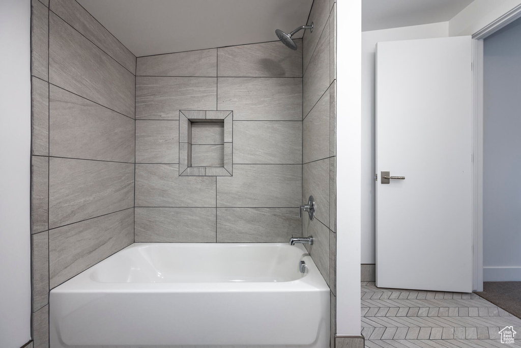 Bathroom featuring tiled shower / bath, tile patterned floors, and vaulted ceiling