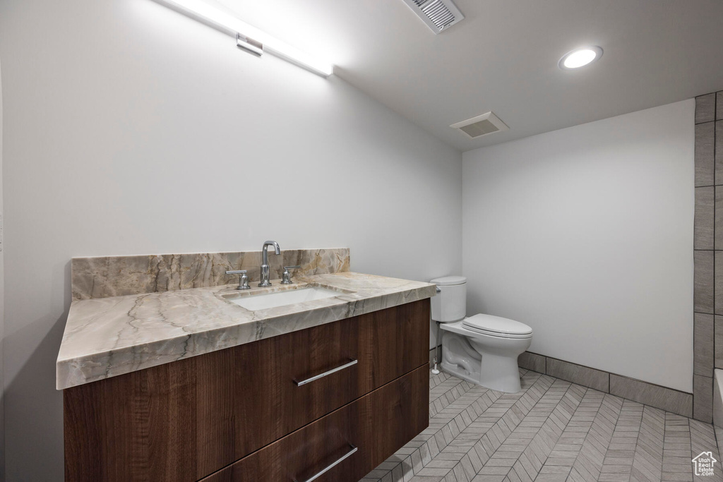 Bathroom with vanity, toilet, and tile patterned floors