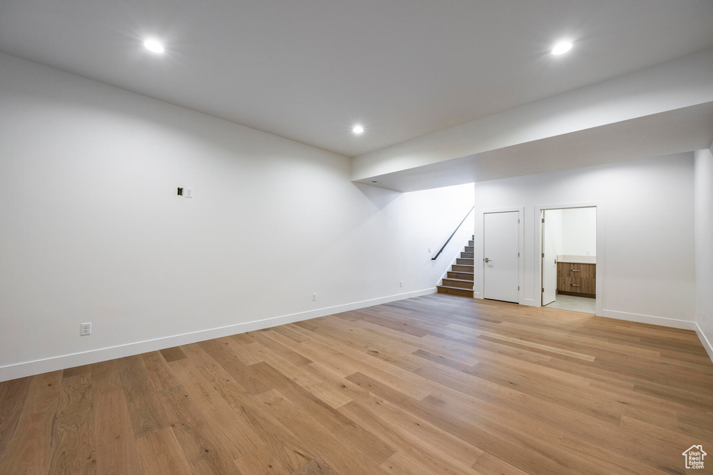 Basement with light hardwood / wood-style flooring