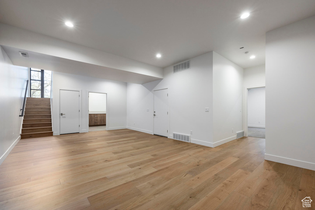 Basement with light hardwood / wood-style flooring