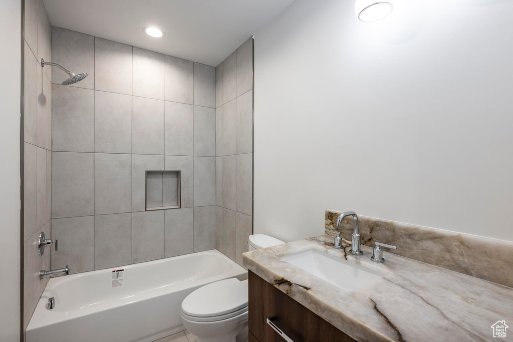 Full bathroom with vanity, toilet, and tiled shower / bath combo