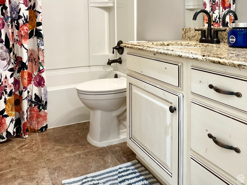 Full bathroom featuring shower / bath combination with curtain, toilet, and vanity