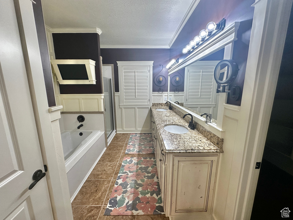 Bathroom with tile patterned flooring, crown molding, vanity, a textured ceiling, and shower with separate bathtub