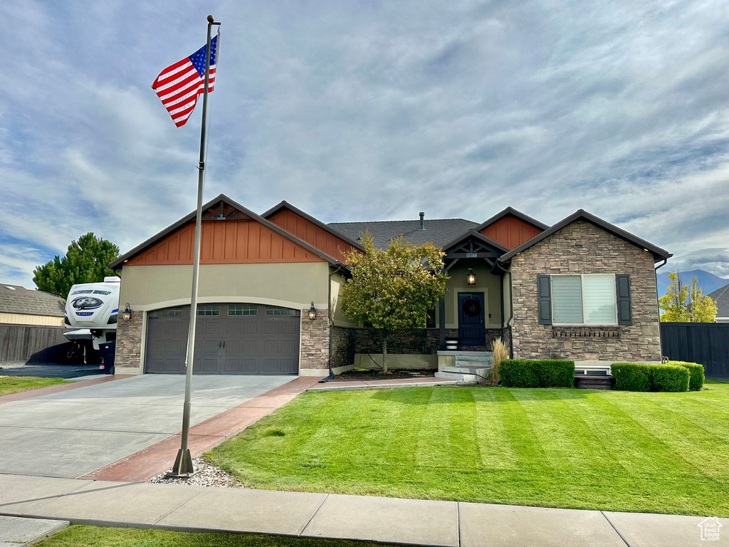 Craftsman house featuring a garage and a front lawn