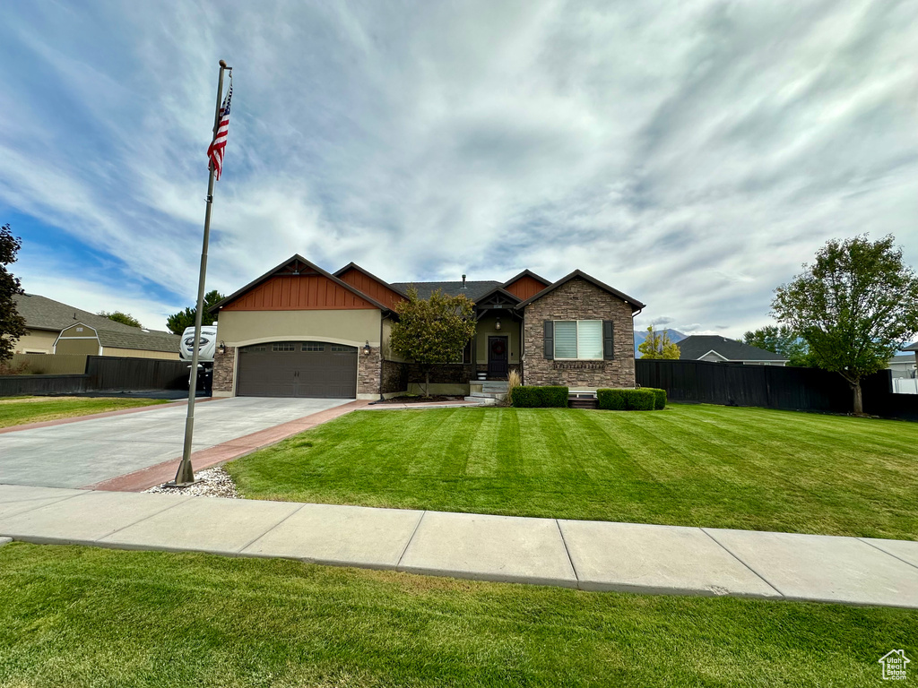 View of front of home featuring a front yard and a garage