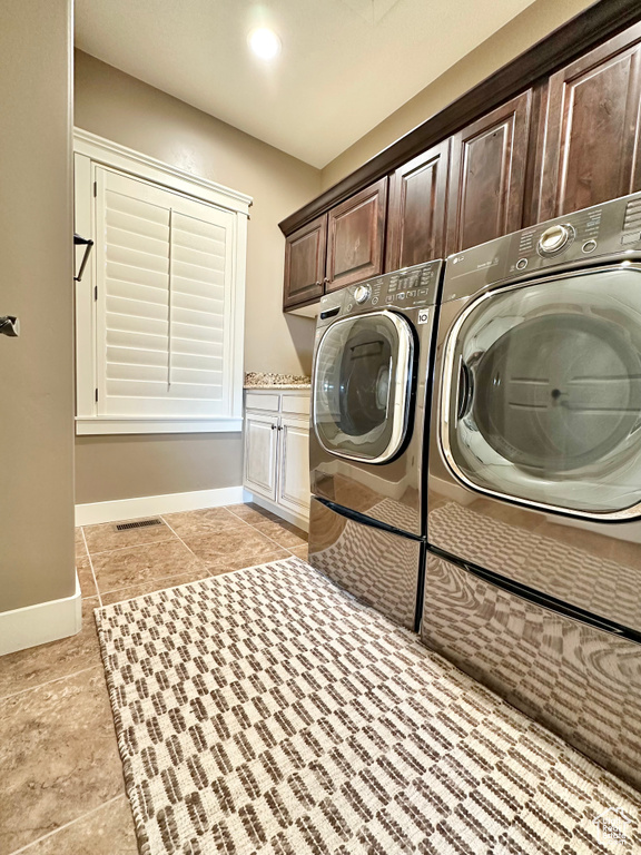 Laundry area with independent washer and dryer and cabinets