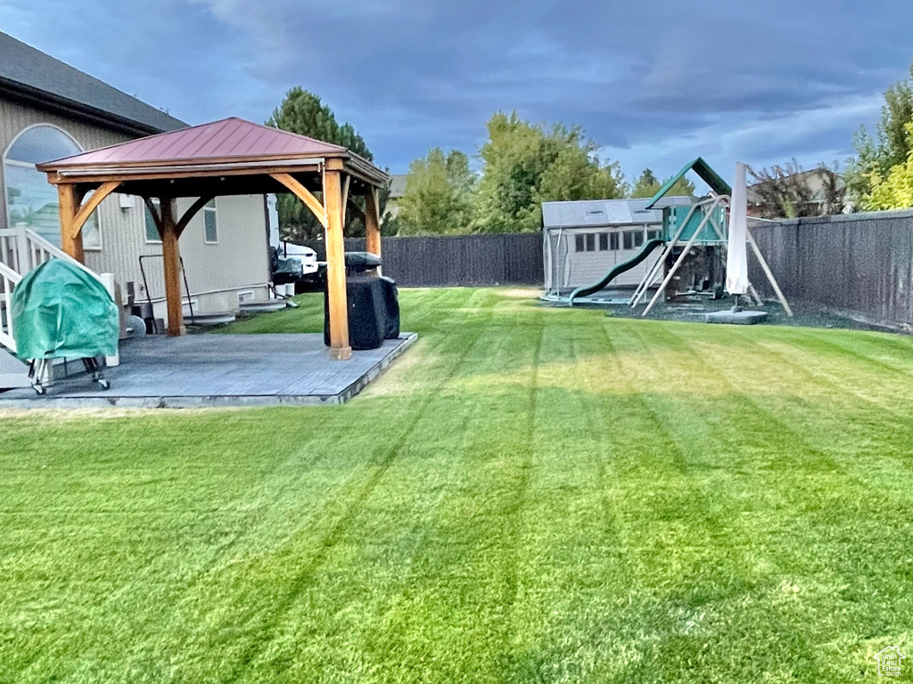 View of yard featuring a storage unit, a patio area, and a gazebo