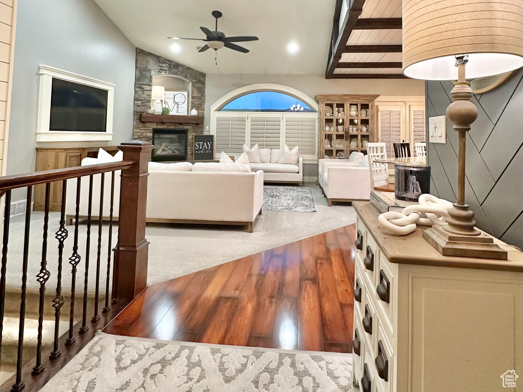 Bedroom with high vaulted ceiling, hardwood / wood-style flooring, a fireplace, and an inviting chandelier