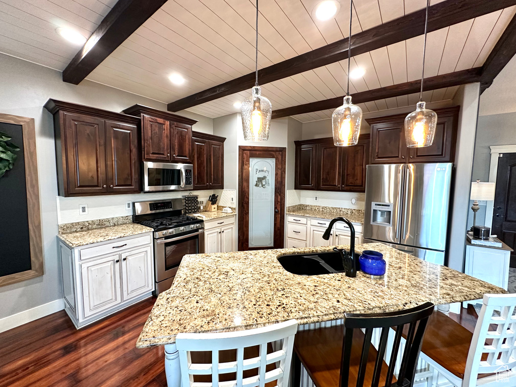 Kitchen with beamed ceiling, stainless steel appliances, a spacious island, dark hardwood / wood-style floors, and sink