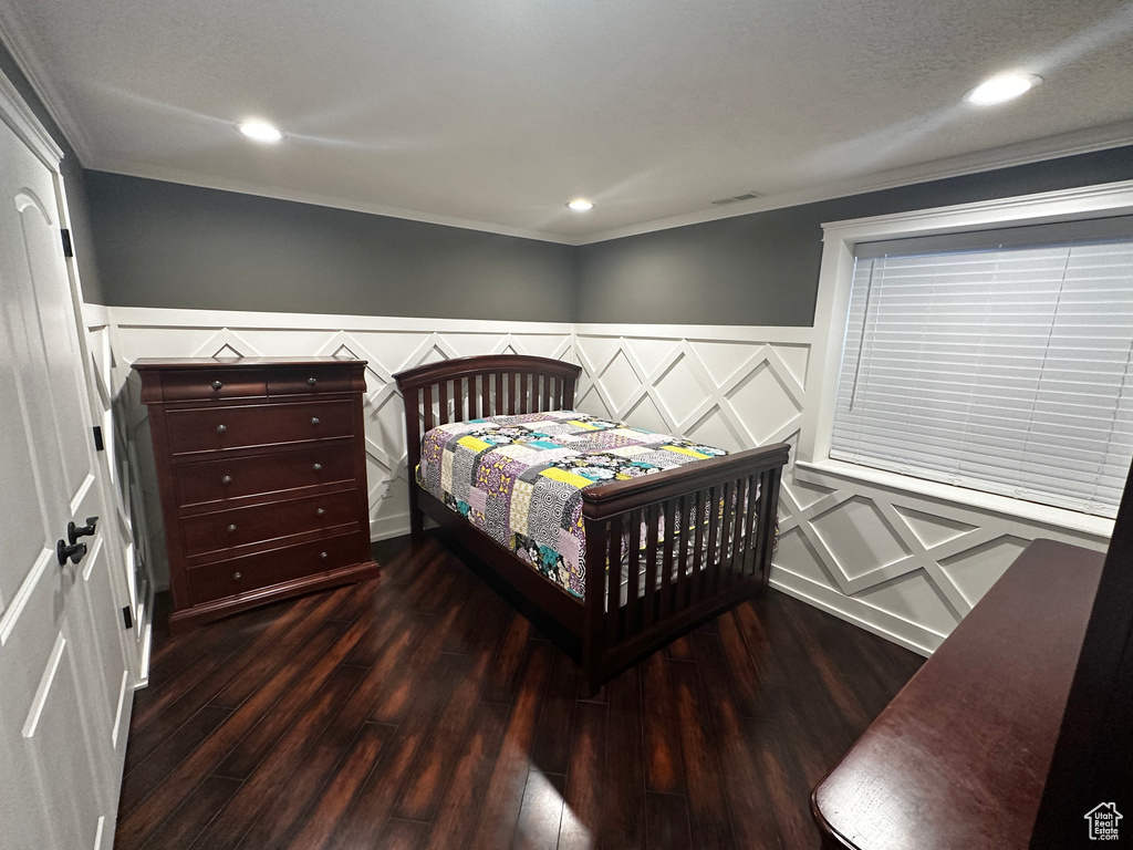 Bedroom featuring dark hardwood / wood-style floors, crown molding, and a textured ceiling