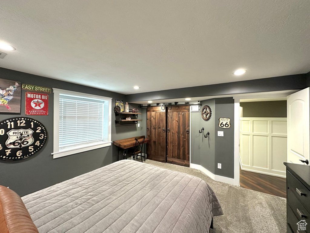 Bedroom with carpet floors and a barn door