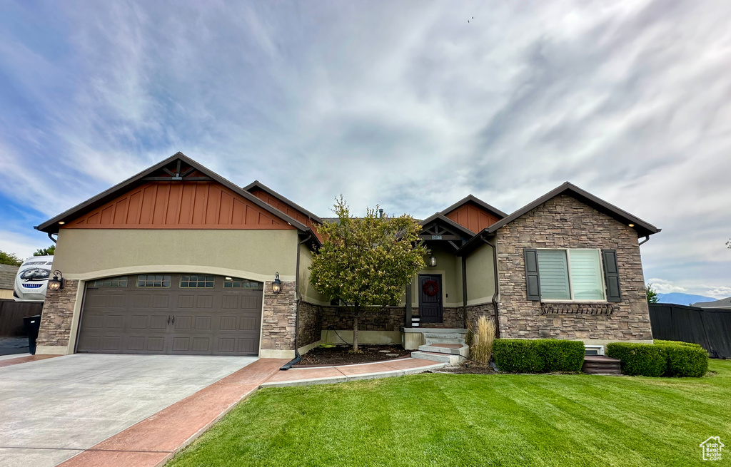 Craftsman-style home featuring a front lawn and a garage