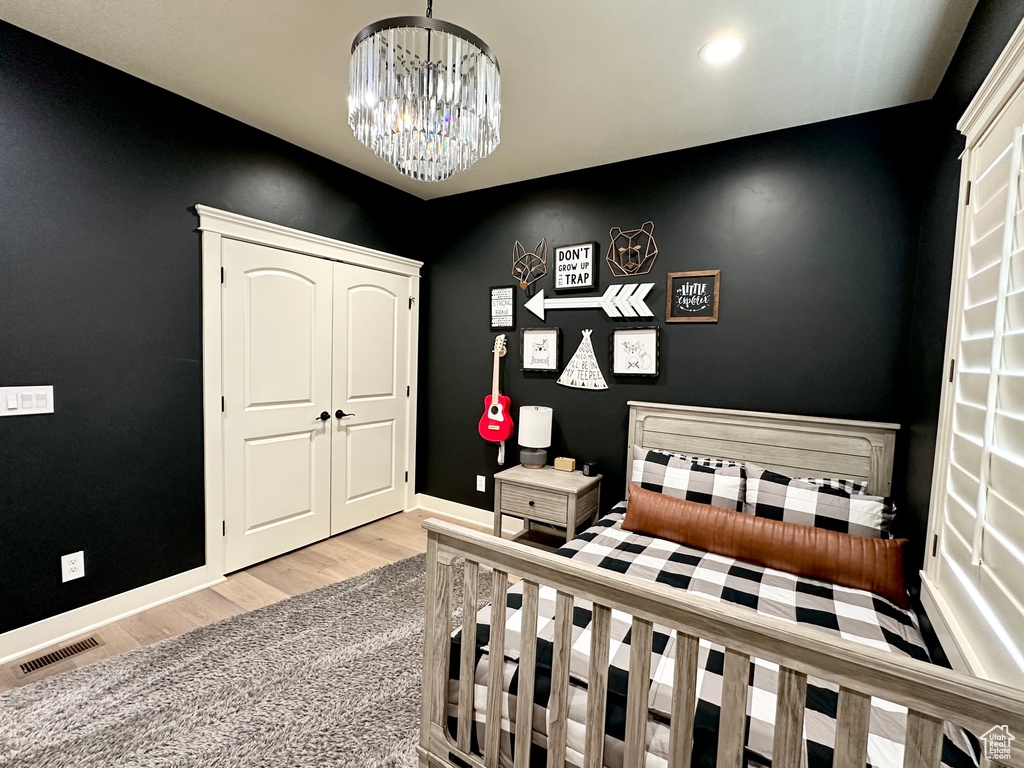 Bedroom featuring a chandelier and light hardwood / wood-style floors