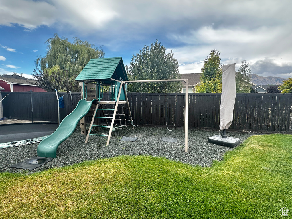 View of playground featuring a mountain view and a yard