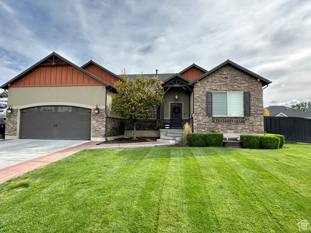 Craftsman-style home featuring a garage and a front lawn