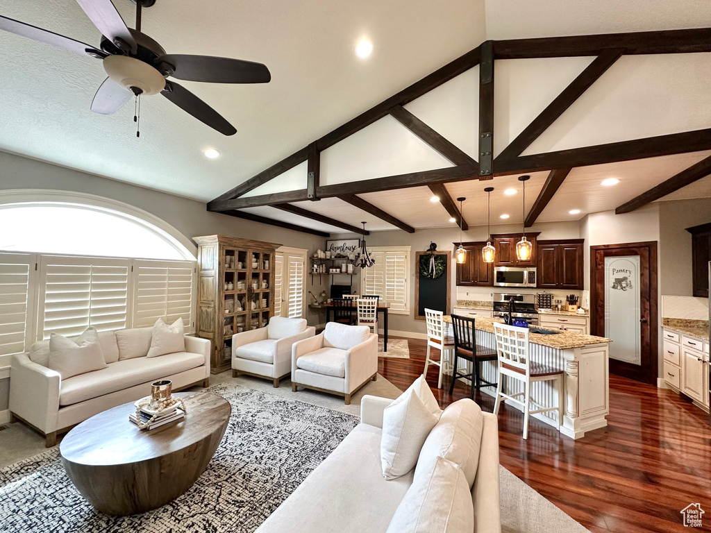 Living room with high vaulted ceiling, beam ceiling, ceiling fan, and dark hardwood / wood-style floors