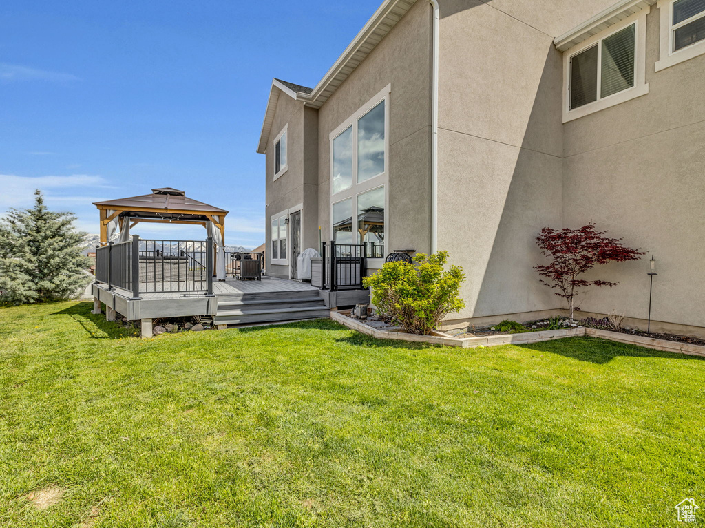 View of yard featuring a gazebo, a deck, and central AC