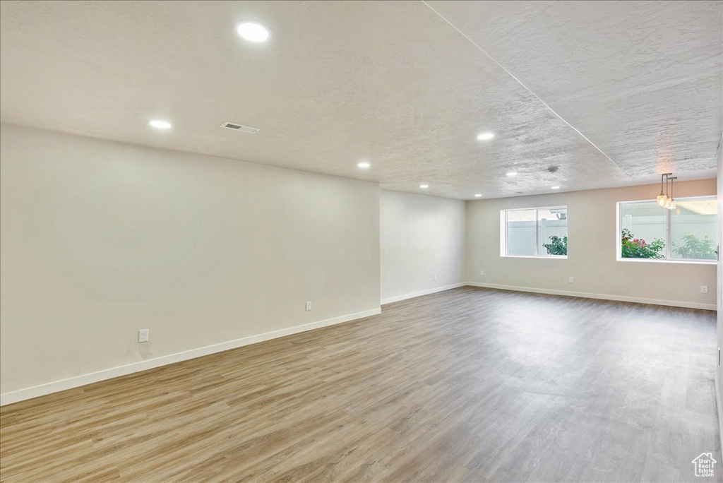 Empty room featuring light hardwood / wood-style floors and a textured ceiling