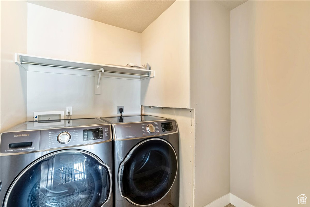 Laundry area featuring a textured ceiling and separate washer and dryer