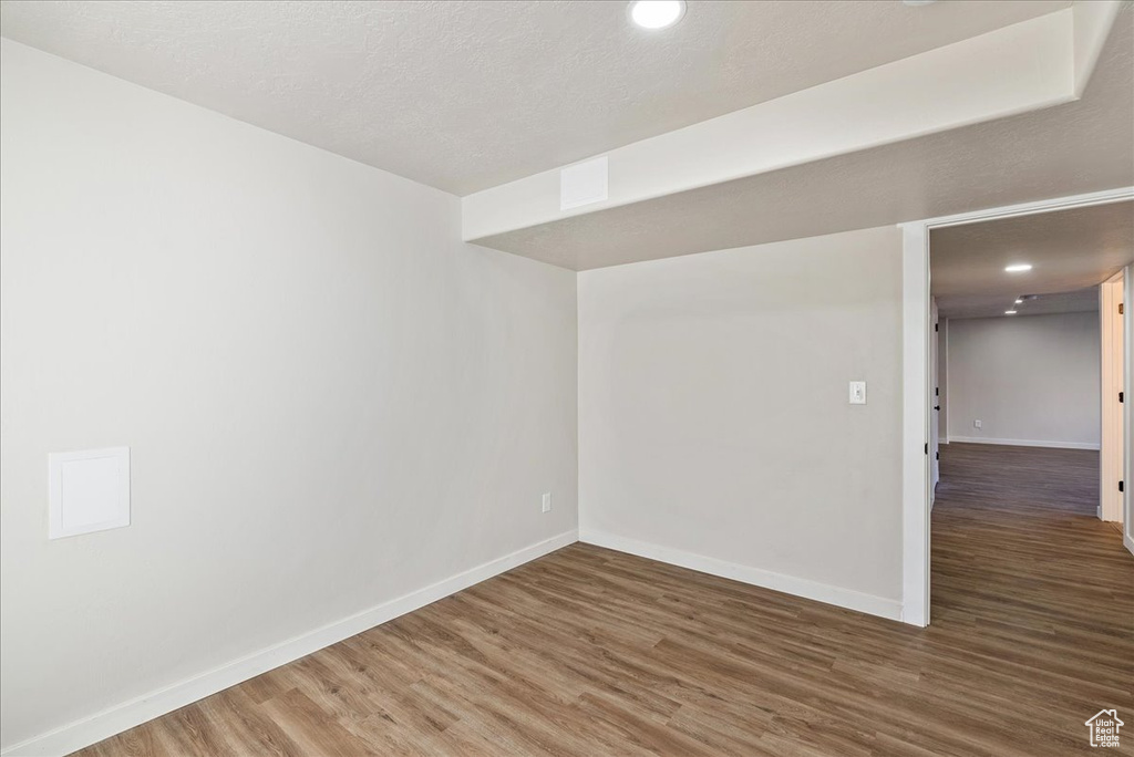 Unfurnished room featuring a textured ceiling and dark hardwood / wood-style floors