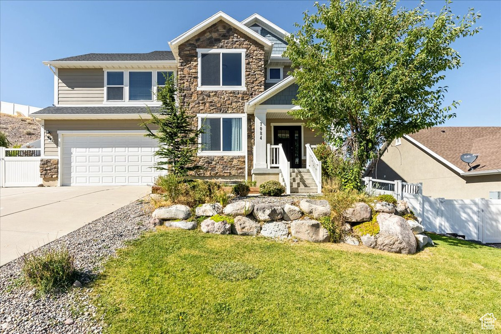 Craftsman inspired home with a porch, a garage, and a front yard