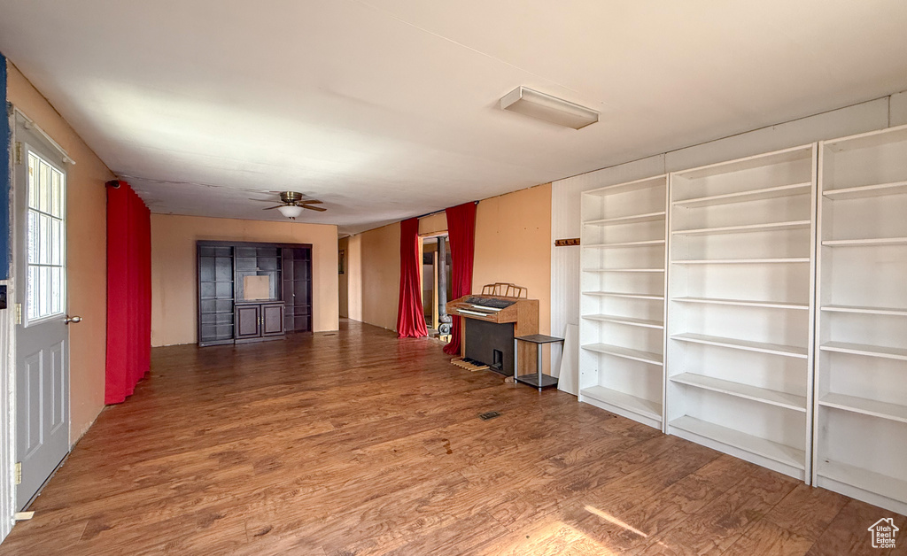 Unfurnished living room featuring a ceiling fan and wood finished floors