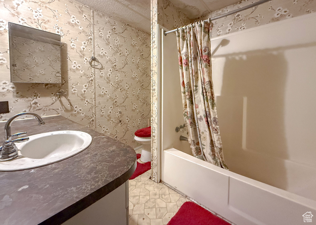 Full bathroom with shower / bathtub combination with curtain, vanity, and wallpapered walls