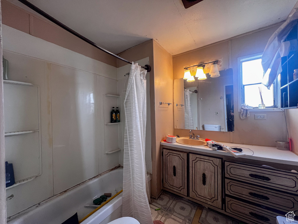 Full bathroom featuring vanity, shower / tub combo, and toilet