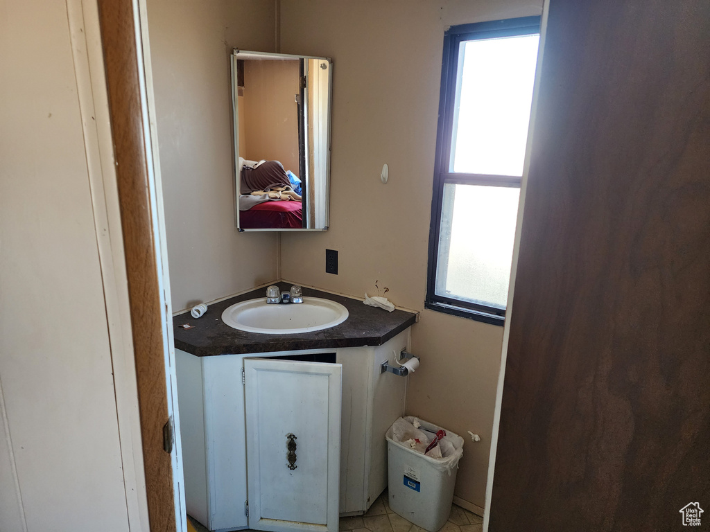 Bathroom featuring tile patterned flooring, vanity, and a wealth of natural light