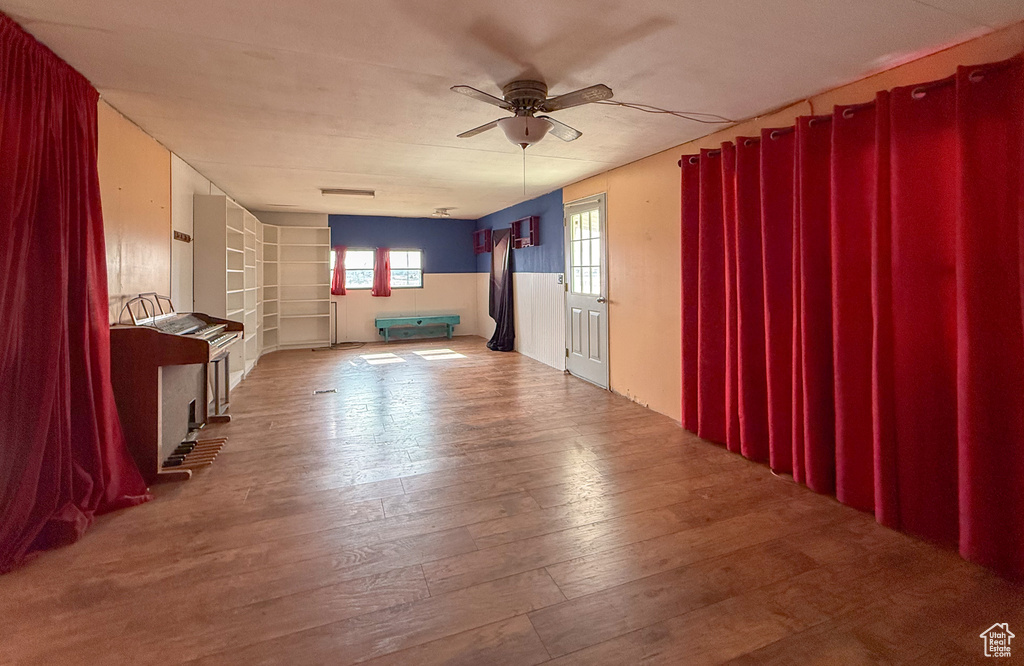 Unfurnished living room with ceiling fan and wood finished floors