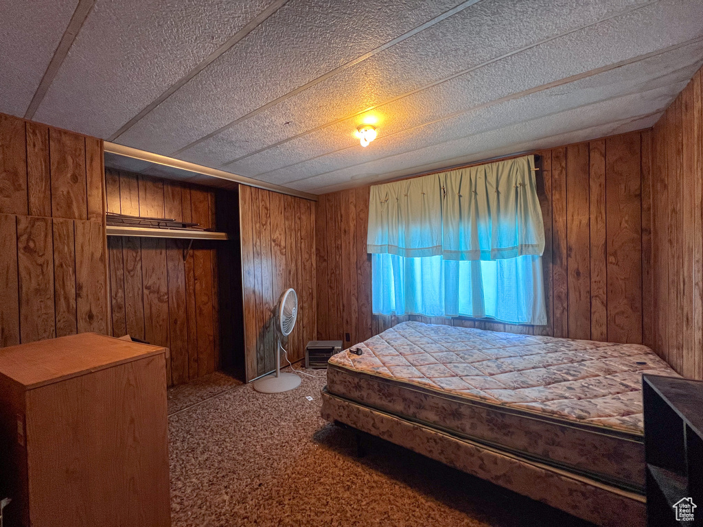 Bedroom with carpet flooring and wooden walls