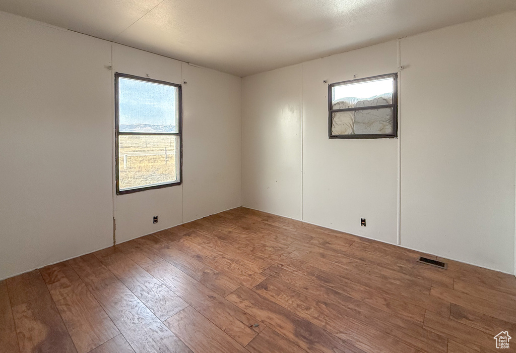 Empty room featuring visible vents and wood finished floors