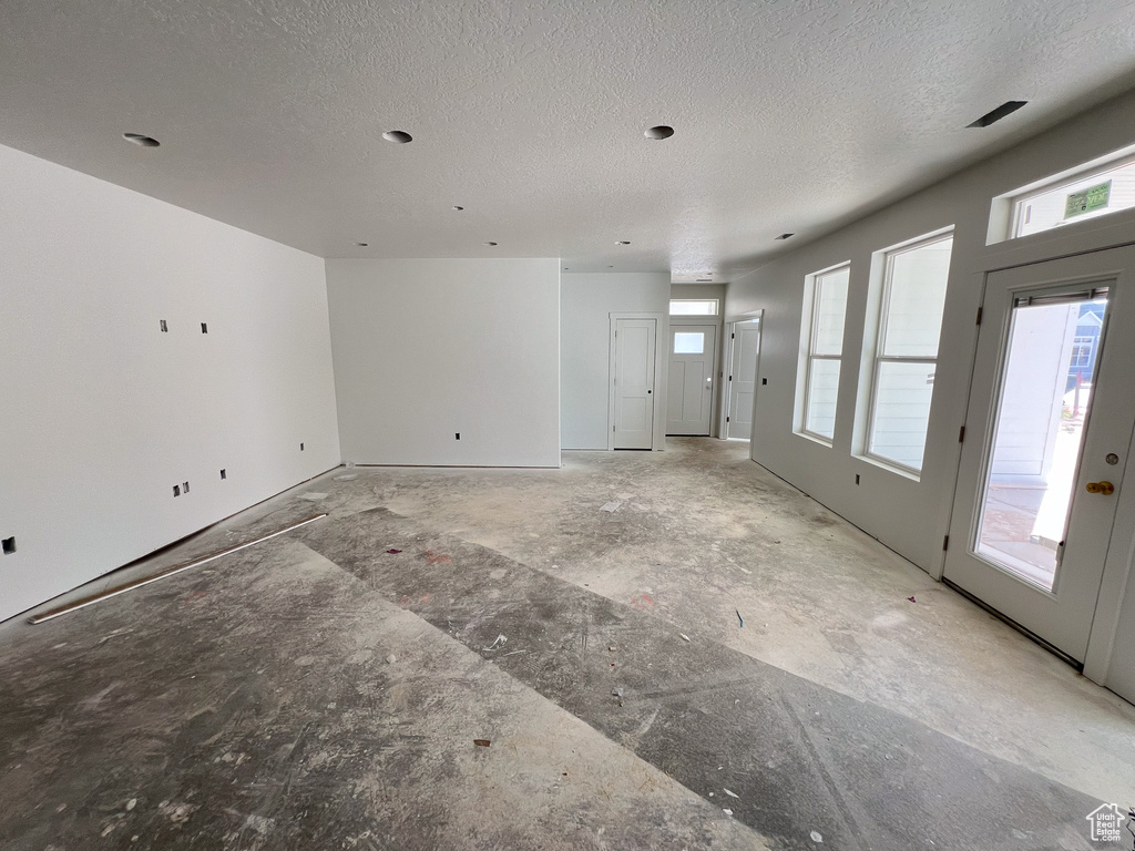 Unfurnished living room featuring a textured ceiling