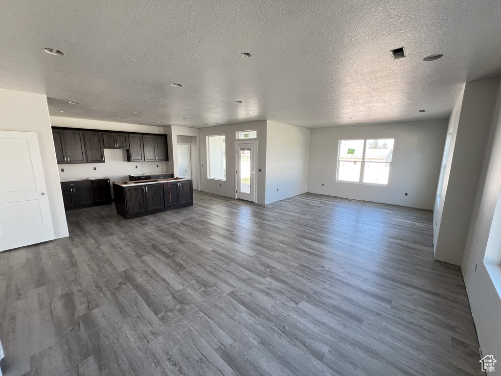 Unfurnished living room with a textured ceiling and hardwood / wood-style floors