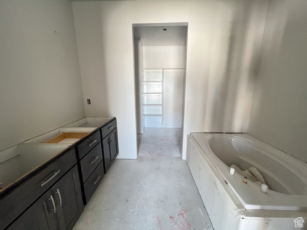 Bathroom featuring vanity, a bathtub, and concrete flooring