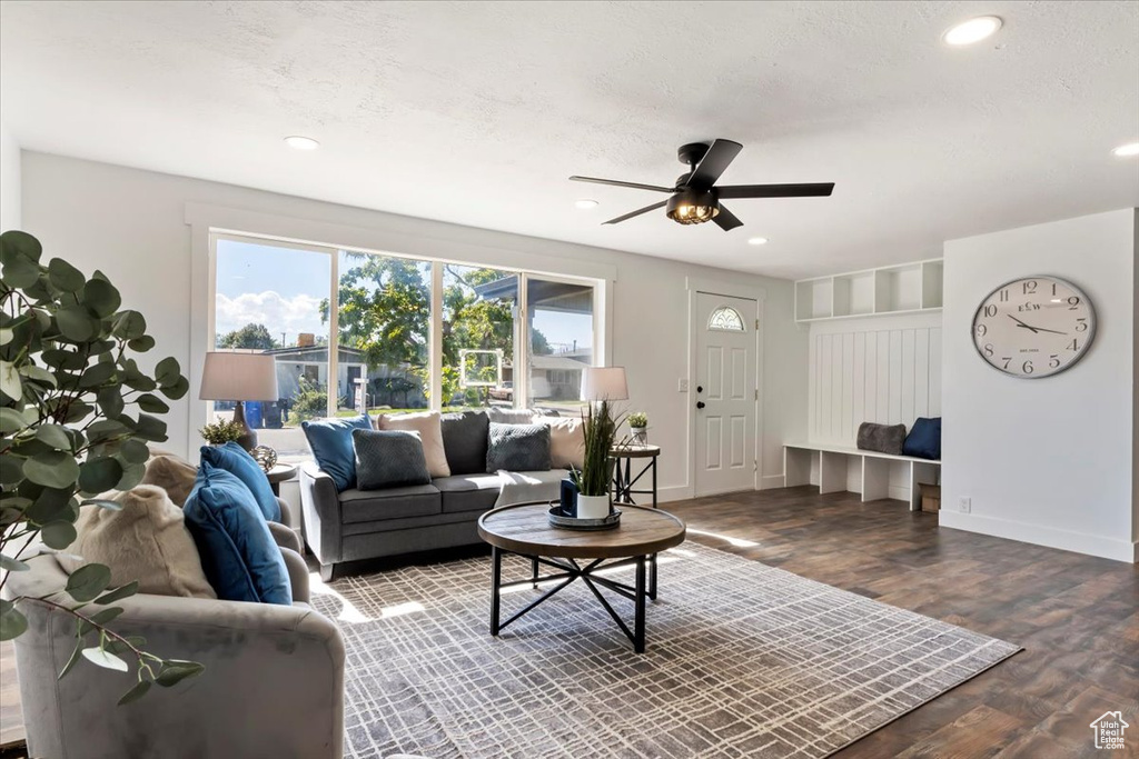 Living room featuring ceiling fan, hardwood / wood-style floors, and a textured ceiling