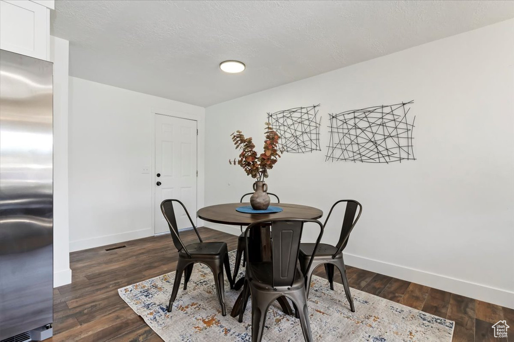 Dining area featuring a textured ceiling and dark wood-type flooring