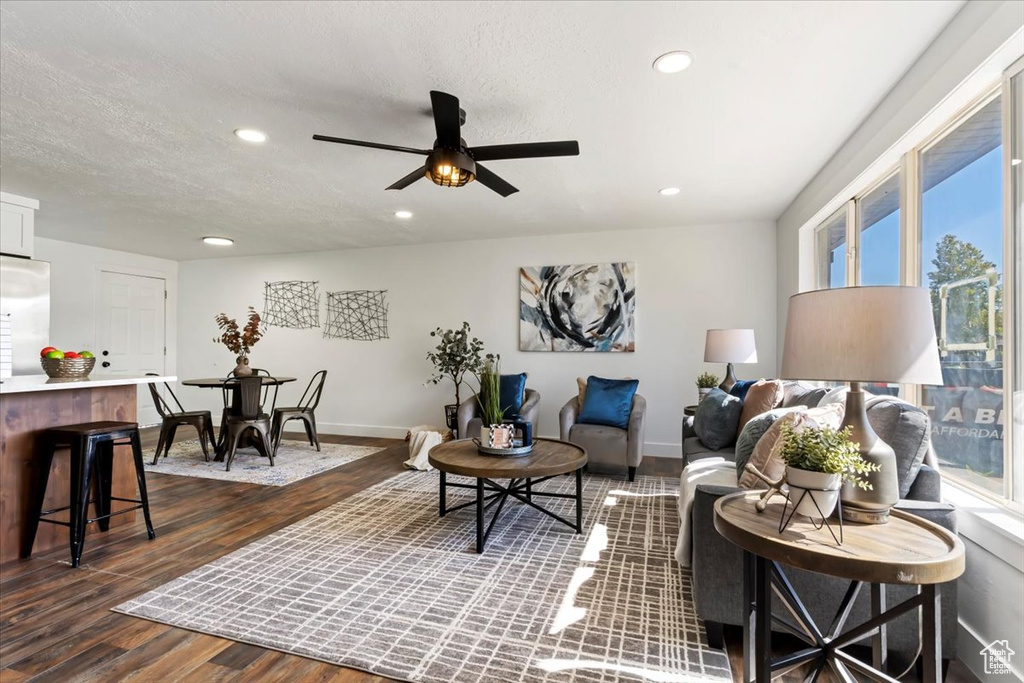 Living room featuring a textured ceiling, dark hardwood / wood-style flooring, and ceiling fan